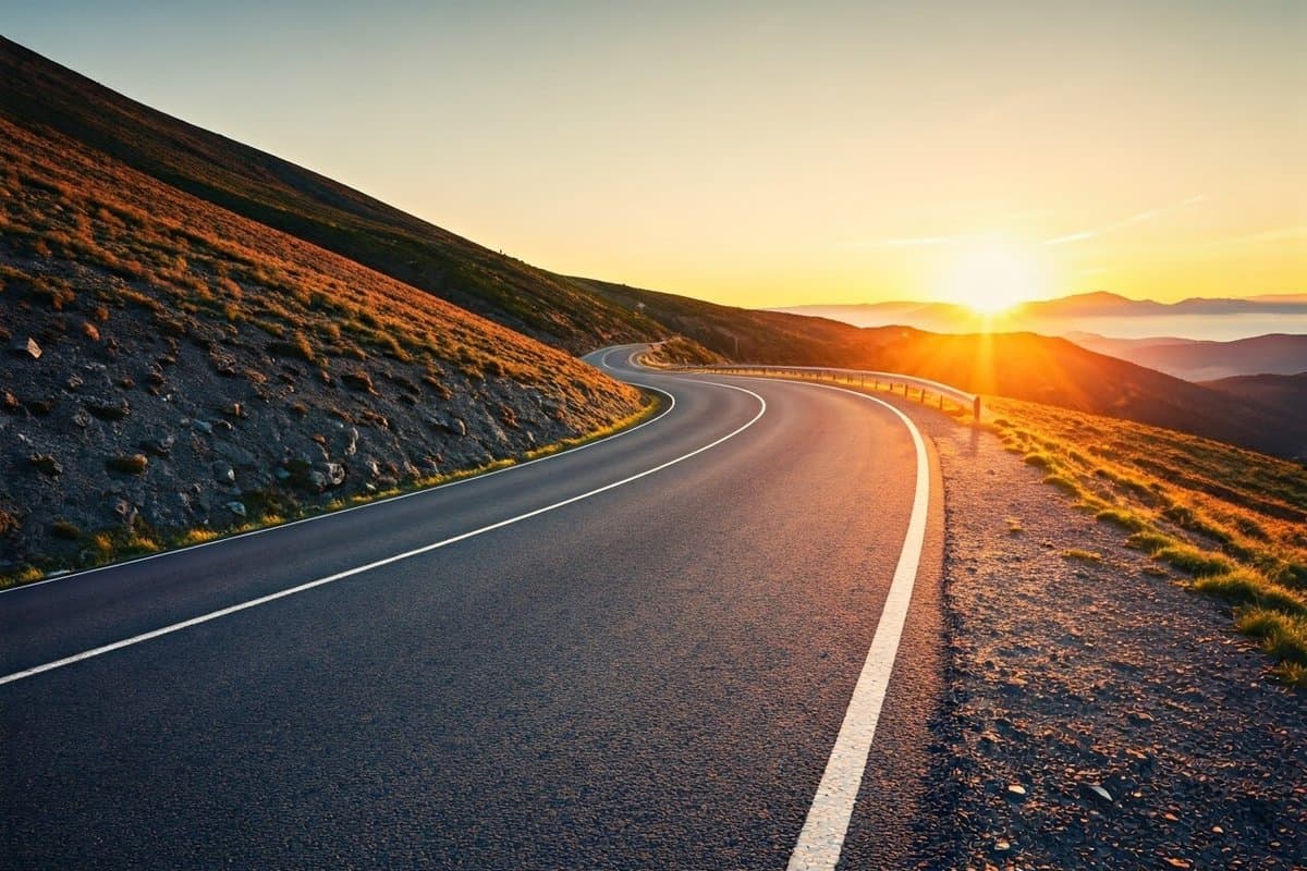 A scenic mountain road at sunrise, symbolizing the journey of self-improvement and the potential for growth through personal responsibility.